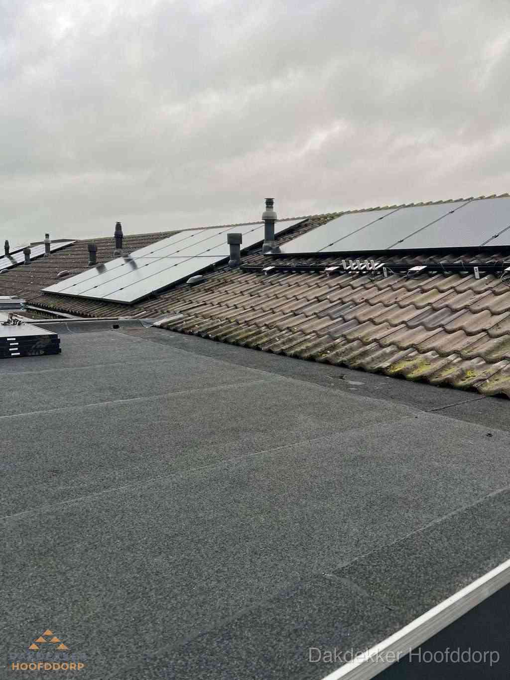 Bitumen dakbedekking op plat dak met aansluitend pannendak en zonnepanelen in Hoofddorp