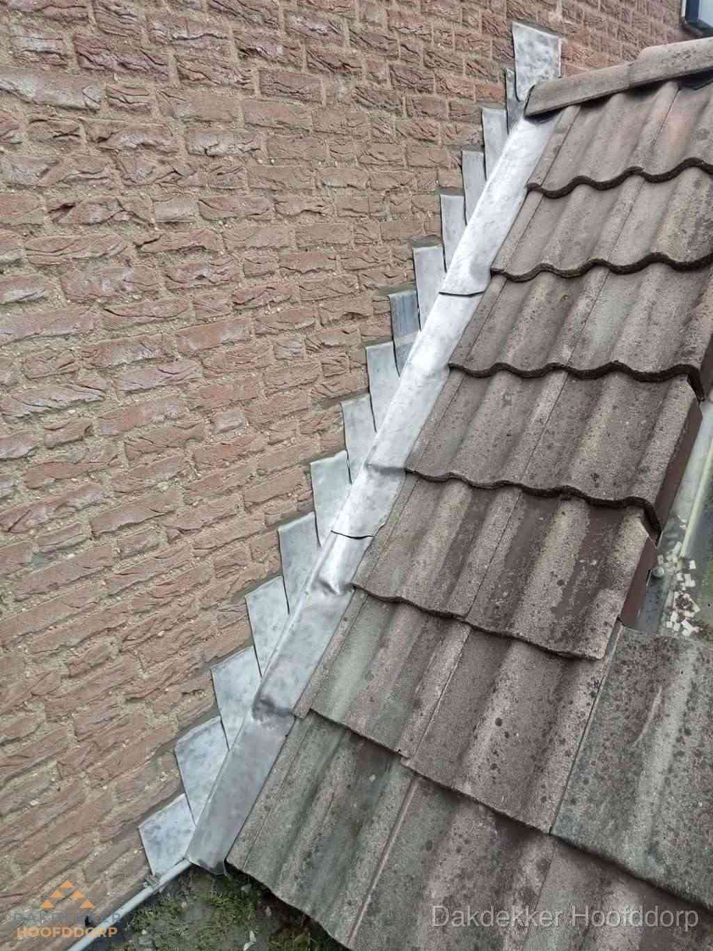 Loodslabben langs dakaansluiting bij bakstenen muur in Hoofddorp
